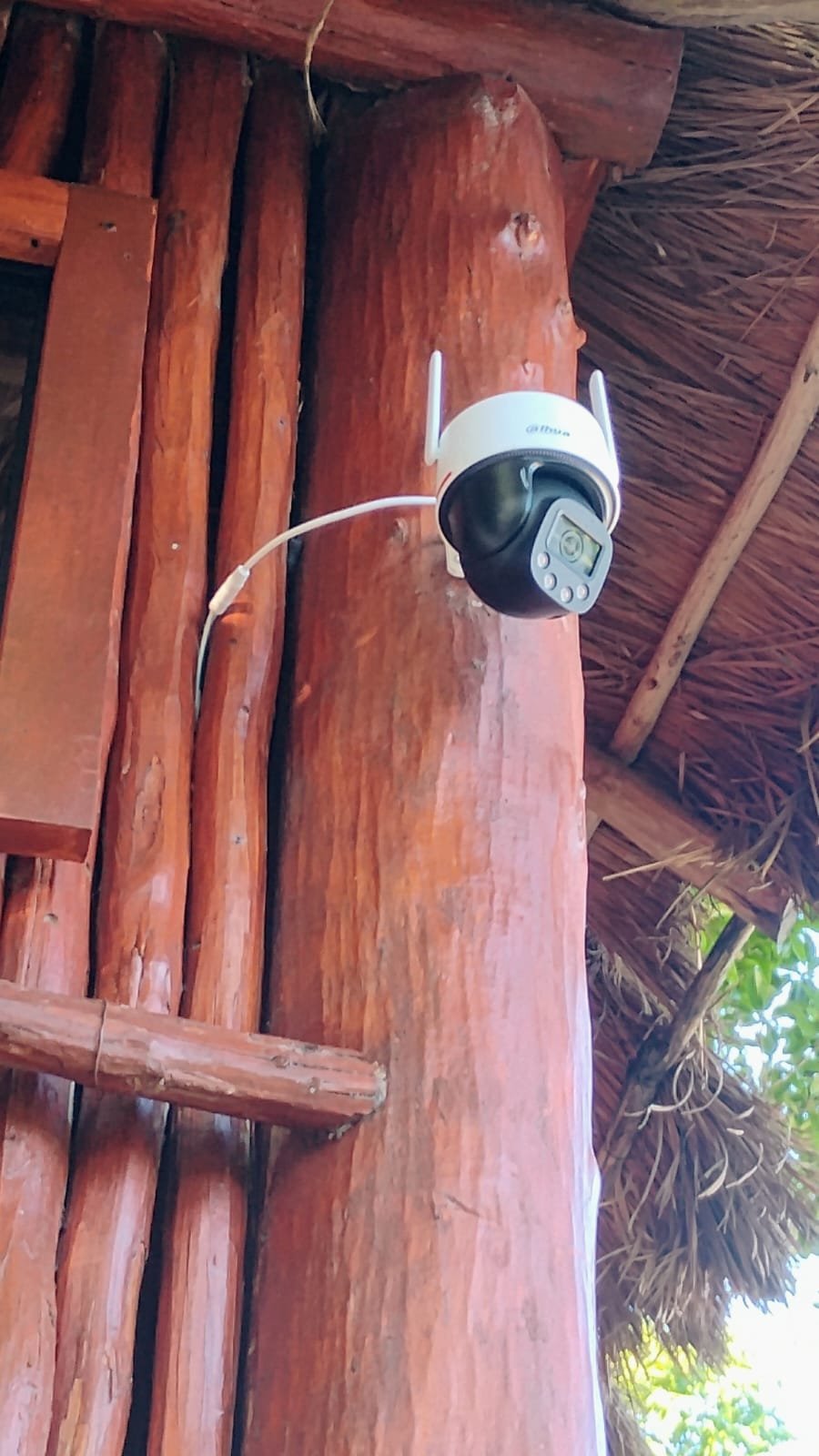 Cámara PTZ Dahua instalada en una columna de madera bajo palapa.