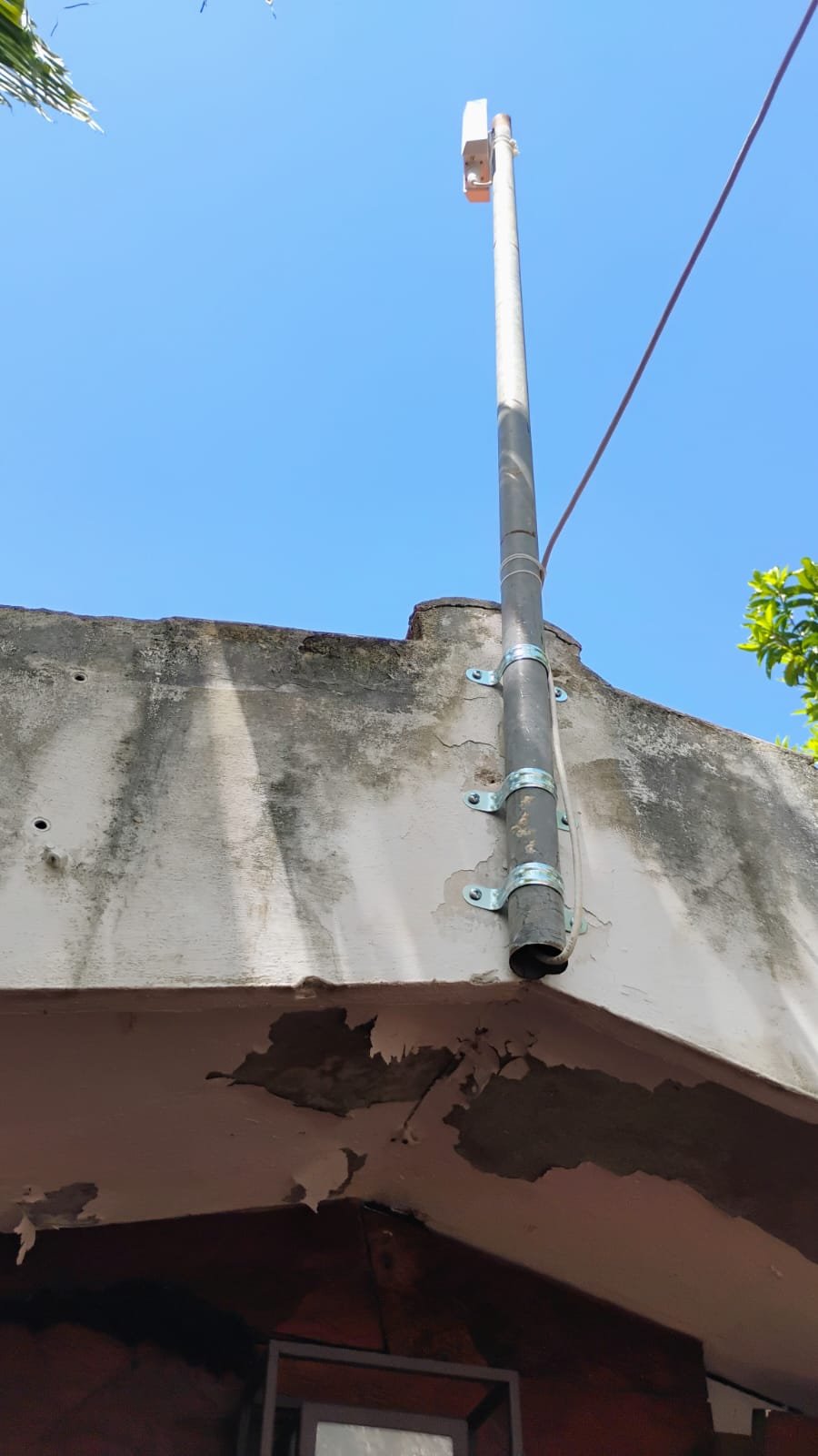 Radio CPE blanco en poste metálico, visto desde un segundo ángulo.